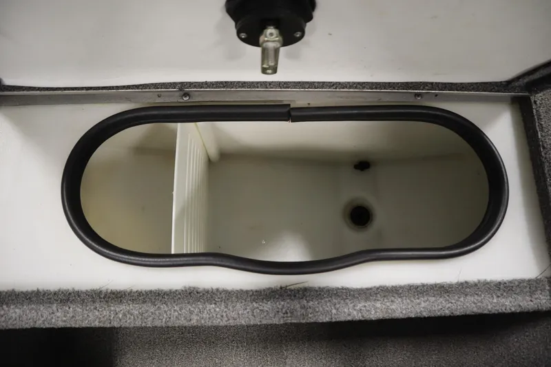 Slide: The Image of Livewell compartment in a 2013 Alumacraft 165 Classic SC boat, featuring a drain hole. - 21
