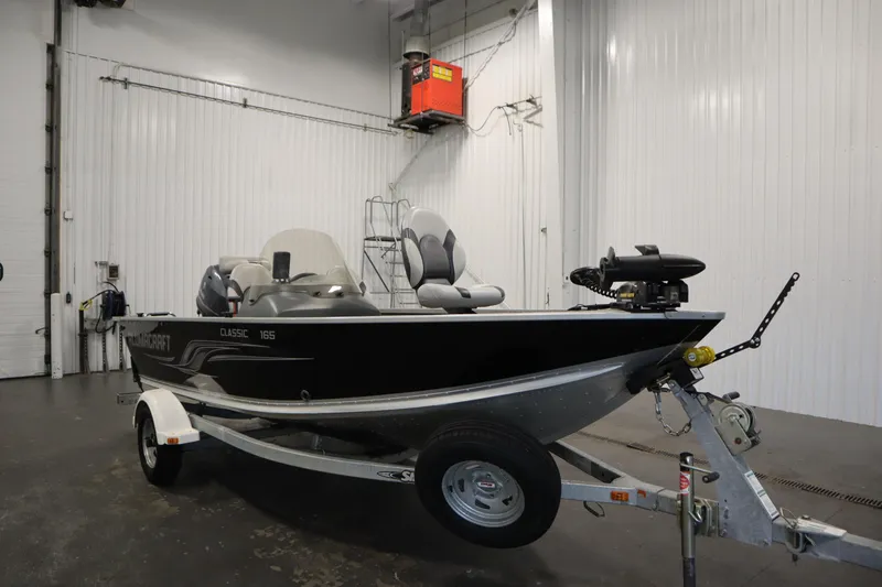 Slide: The Image of 2013 Alumacraft 165 Classic SC boat on trailer in indoor storage. - 3