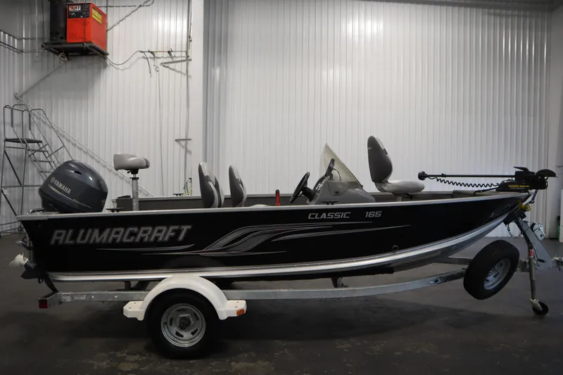 Slide: The Image of 2013 Alumacraft 165 Classic SC boat in a garage, featuring Yamaha motor. - 4