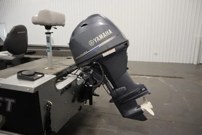 Slide: The Image of 2013 Alumacraft 165 Classic SC boat with Yamaha outboard motor in a garage setting. - 48