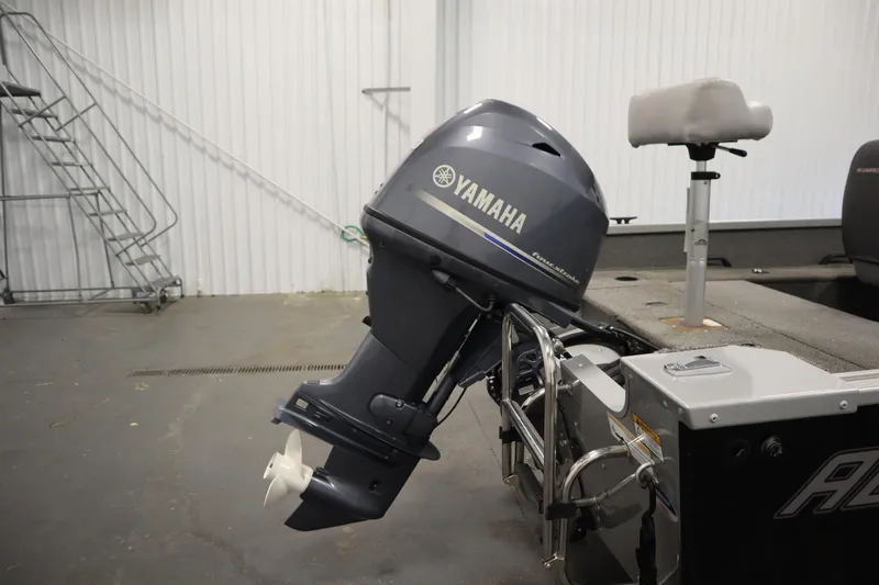 Slide: The Image of 2013 Alumacraft 165 Classic SC boat with Yamaha outboard motor in a garage. - 49