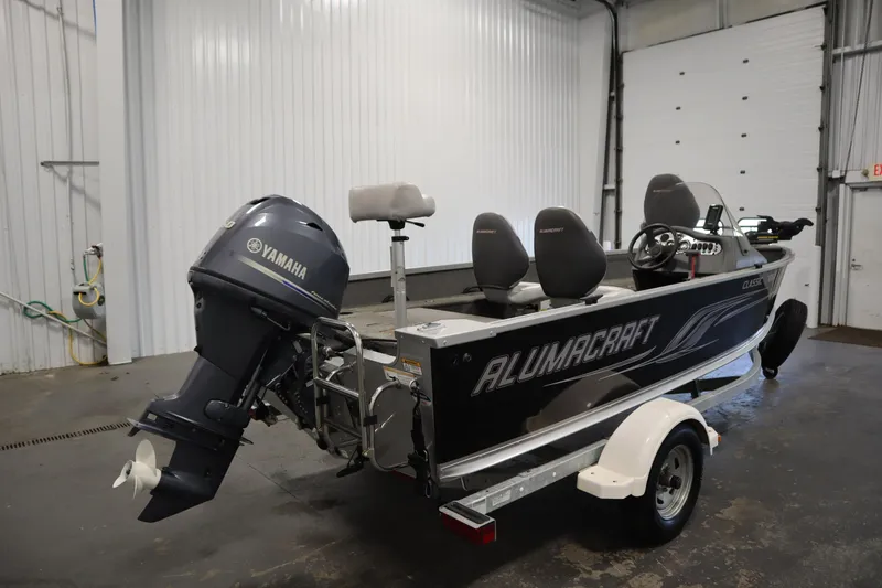 Slide: The Image of 2013 Alumacraft 165 Classic SC boat with Yamaha motor in a garage setting. - 5