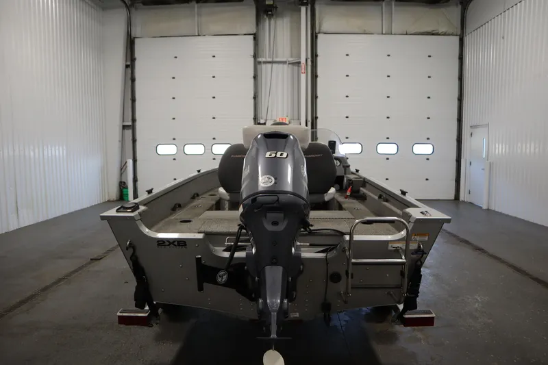 Slide: The Image of 2013 Alumacraft 165 Classic SC boat in a garage, rear view with motor. - 6