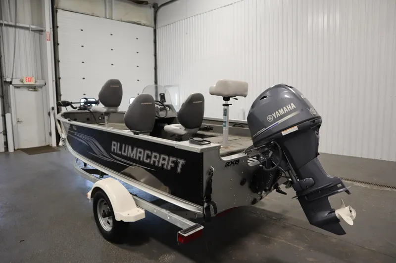 Slide: The Image of 2013 Alumacraft 165 Classic SC boat with Yamaha motor in a garage setting. - 7