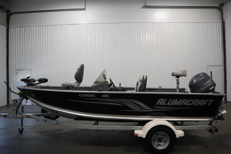 Slide: The Image of 2013 Alumacraft 165 Classic SC boat on trailer in indoor setting. - 8