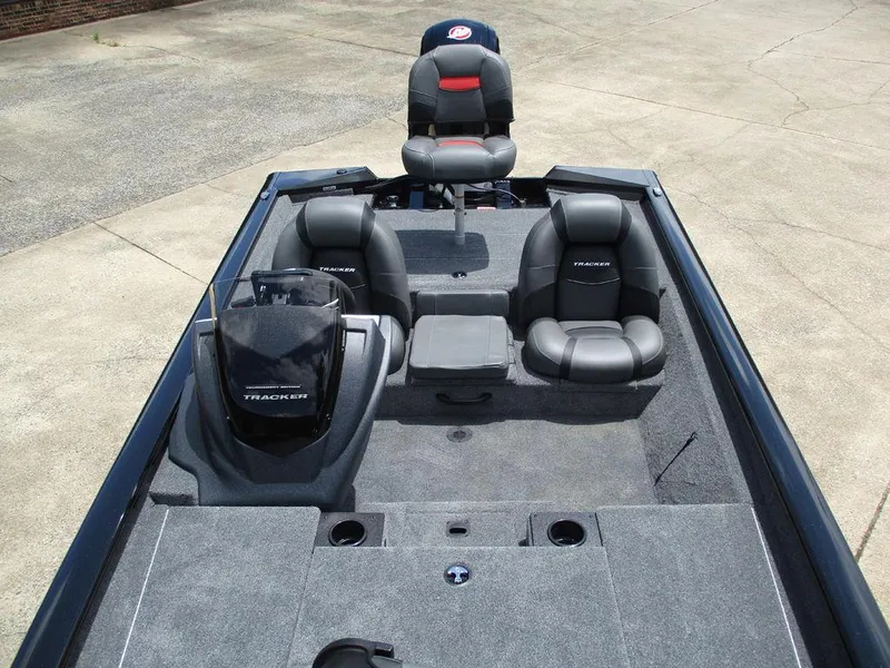 Slide: The Image of 2026 Tracker Pro Team™ 190 boat interior with seating and console, parked on concrete. - 9