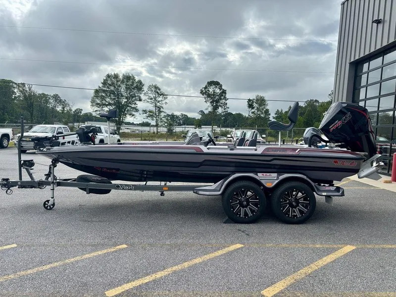 Slide: The Image of 2026 Bass Cat Lynx STS boat on trailer, parked outdoors near a building. - 13