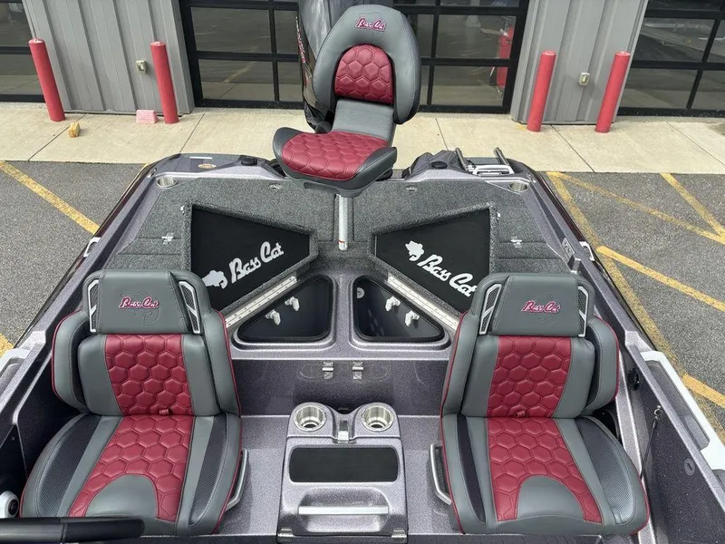 Slide: The Image of 2026 Bass Cat Lynx STS boat interior with red and gray seats, cup holders, and storage compartments. - 17