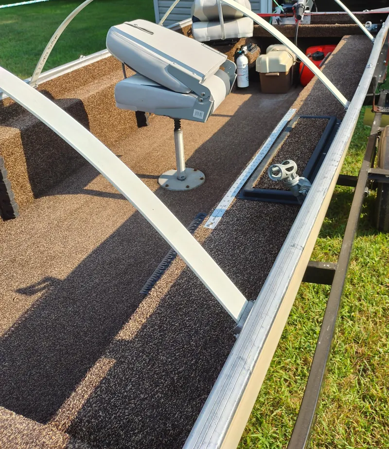 Slide: The Image of 1984 Tuffy Roustabout 149 boat interior with seating and equipment on a sunny day. - 4