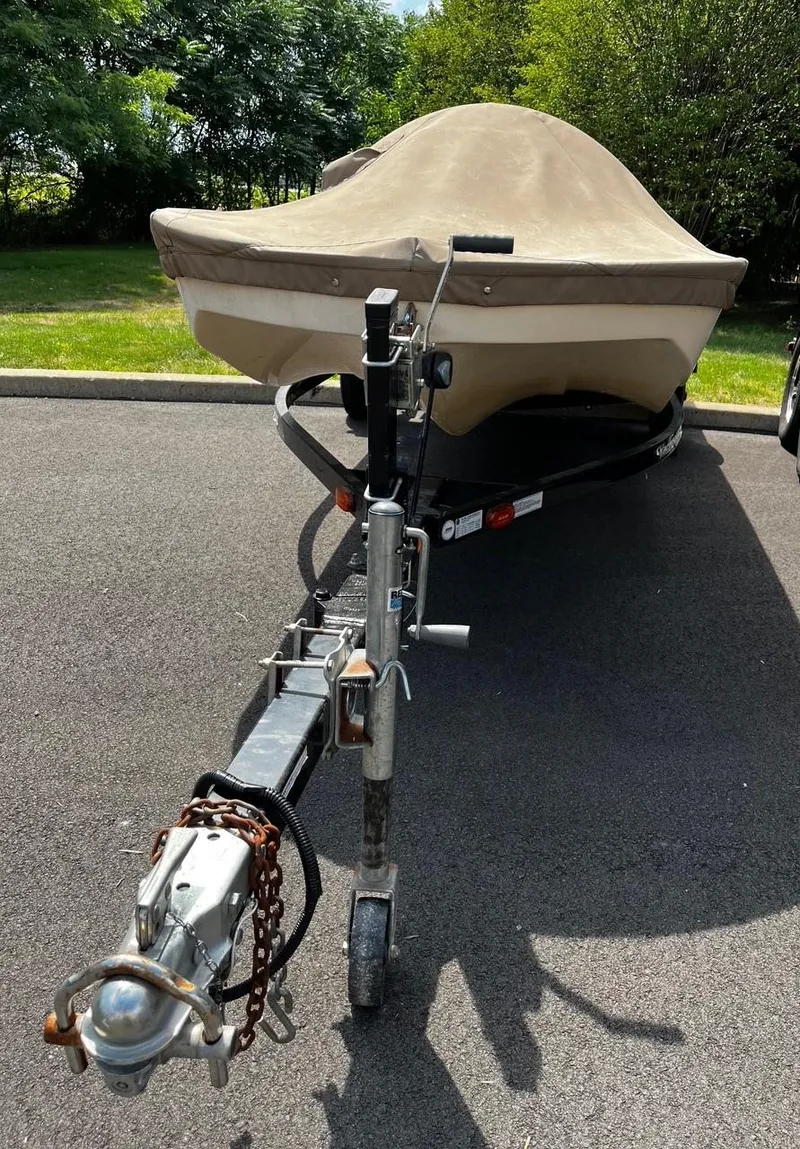 Slide: The Image of 1984 Tuffy Roustabout 149 boat on trailer with cover, parked on asphalt. - 6