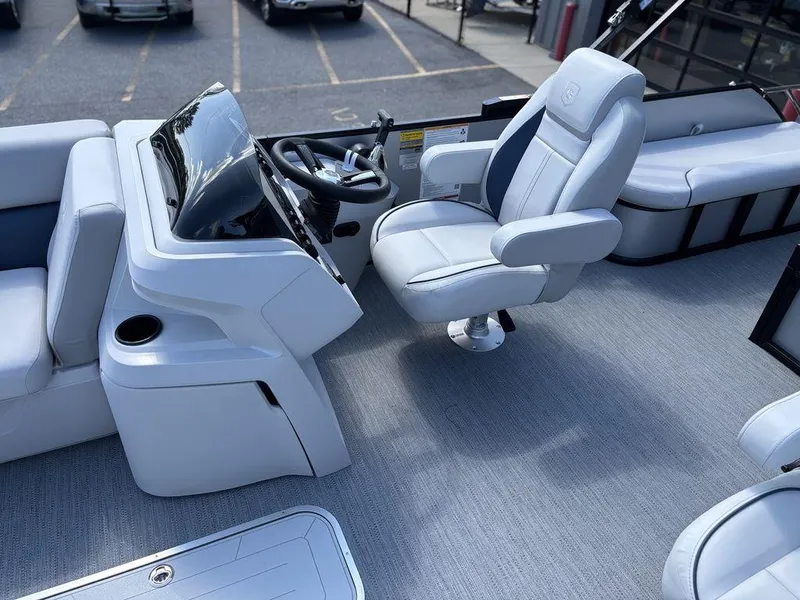 Slide: The Image of 2026 Godfrey SWEETWATER 2286 SFL boat interior with captain's chair and steering console. - 13