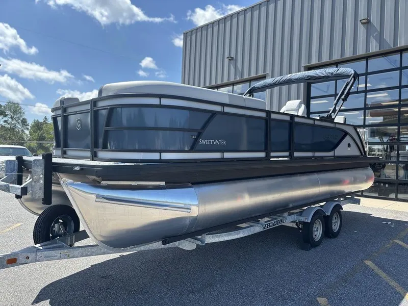 Slide: The Image of 2026 Godfrey SWEETWATER 2286 SFL pontoon boat on trailer, parked outdoors. - 2