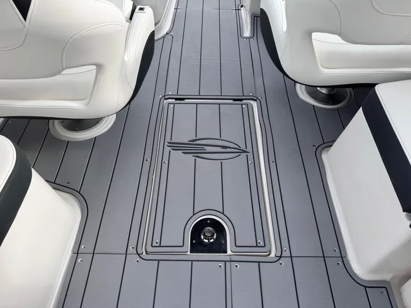 Slide: The Image of 2025 Chaparral 307 SSX boat interior with sleek gray flooring and white seating. - 12