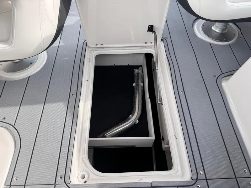 Slide: The Image of 2025 Chaparral 307 SSX boat storage compartment with open hatch and visible pipe. - 14