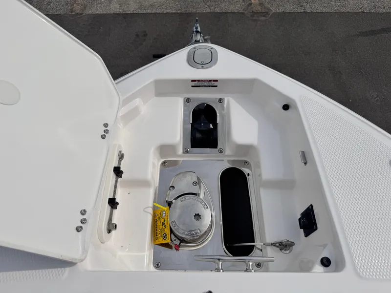 Slide: The Image of 2025 Chaparral 307 SSX boat anchor compartment with open hatch and visible winch. - 16