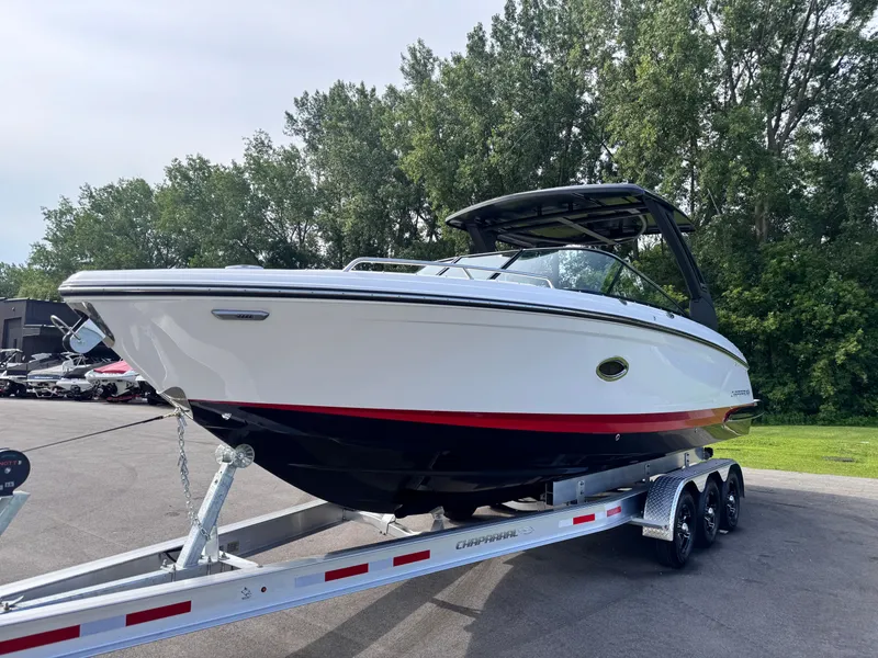 Slide: The Image of 2025 Chaparral 307 SSX boat on trailer, parked outdoors with trees in background. - 2