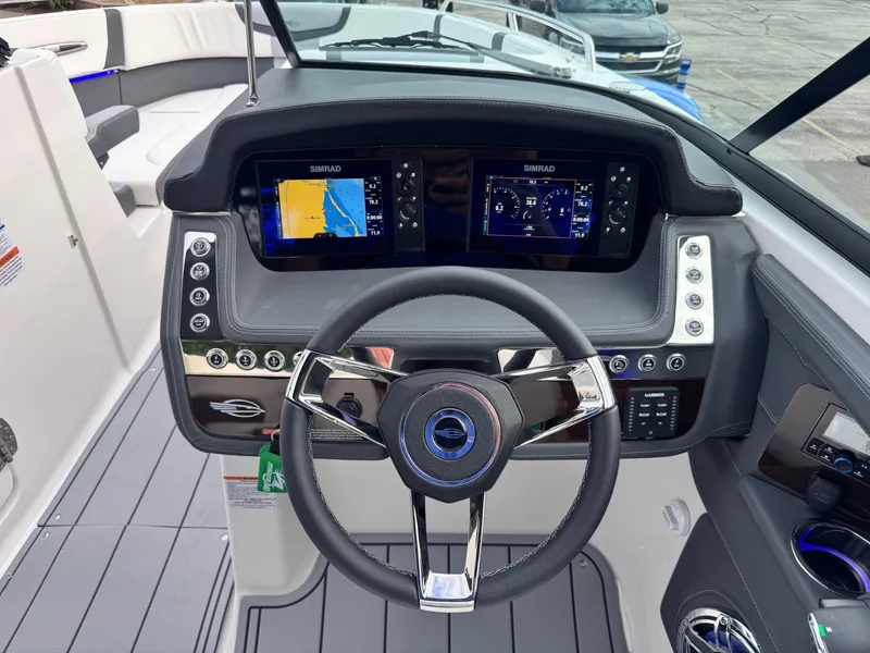 Slide: The Image of 2025 Chaparral 307 SSX boat dashboard with dual Simrad displays and modern steering wheel. - 33
