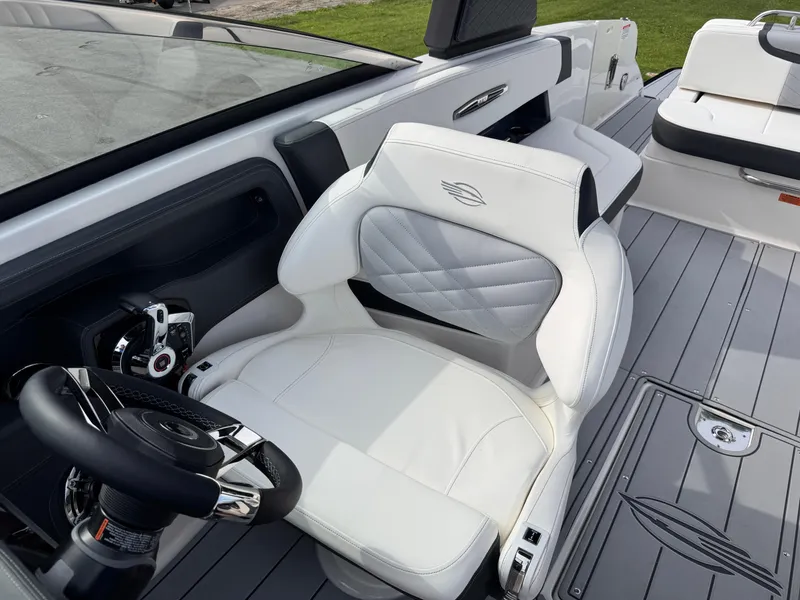 Slide: The Image of 2025 Chaparral 307 SSX boat interior with white leather seating and modern steering controls. - 34