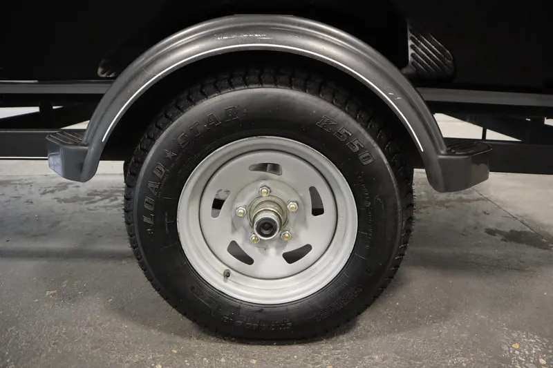 Slide: The Image of 2018 Tracker Panfish 16 trailer wheel with Loadstar tire in a garage setting. - 37
