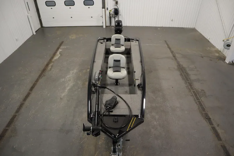 Slide: The Image of 2018 Tracker Panfish 16 boat in a garage, featuring dual seats and trolling motor. - 9