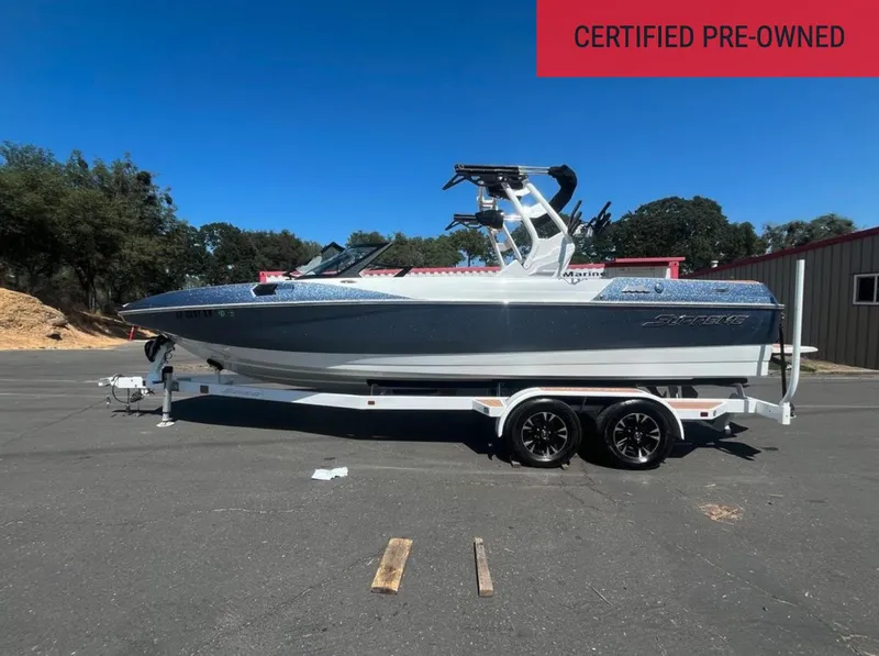 Slide: The Image of Certified pre-owned 2021 Supreme S 238 boat on trailer, parked outdoors under clear blue sky. - 1