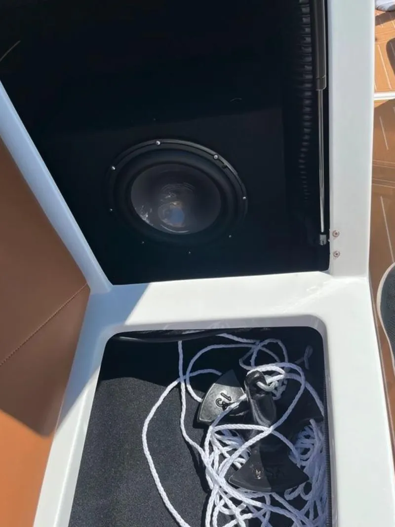 Slide: The Image of Storage compartment in a 2021 Supreme S 238 boat with speaker and ropes. - 25