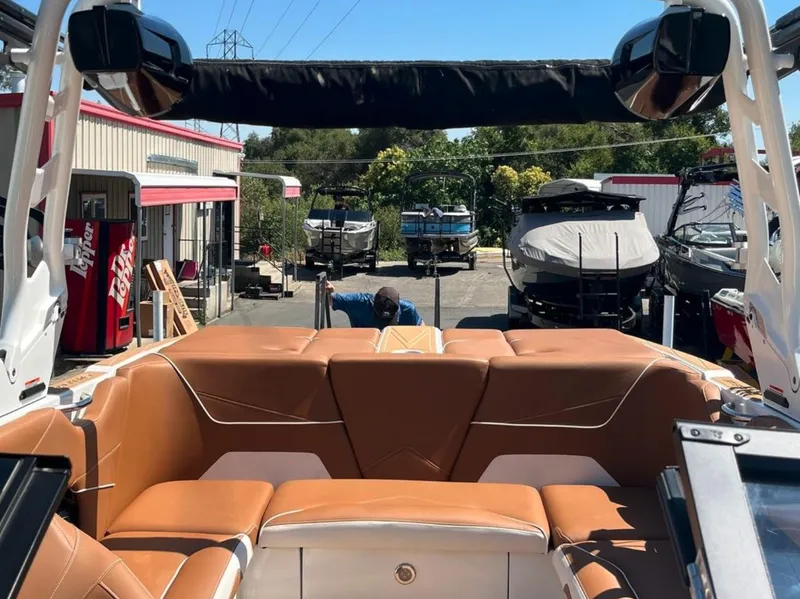 Slide: The Image of 2021 Supreme S 238 boat interior with tan seating, docked near other boats. - 27
