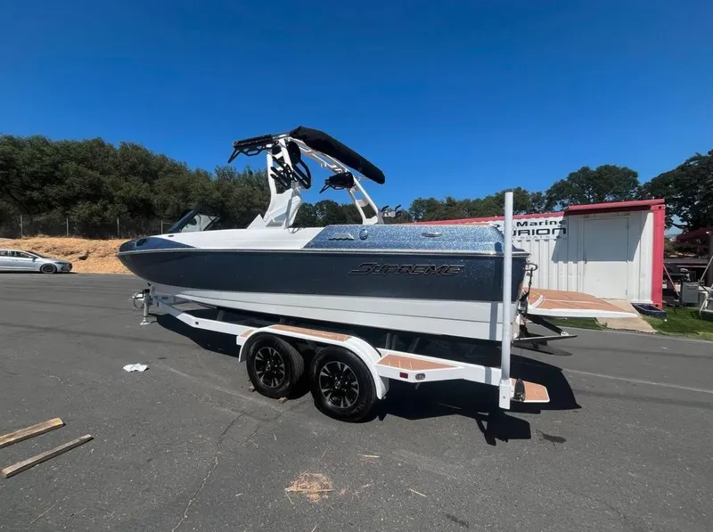 Slide: The Image of 2021 Supreme S 238 boat on trailer, parked outdoors under clear blue sky. - 31