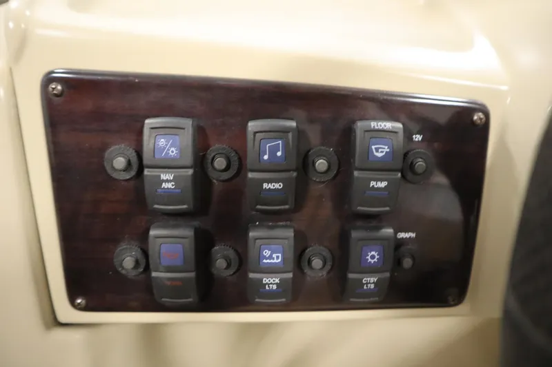 Slide: The Image of Control panel of a 2019 Sylvan 820 Mirage boat with various switches. - 22