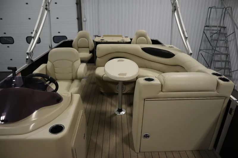 Slide: The Image of 2019 Sylvan 820 Mirage pontoon boat interior with beige seating and table. - 27
