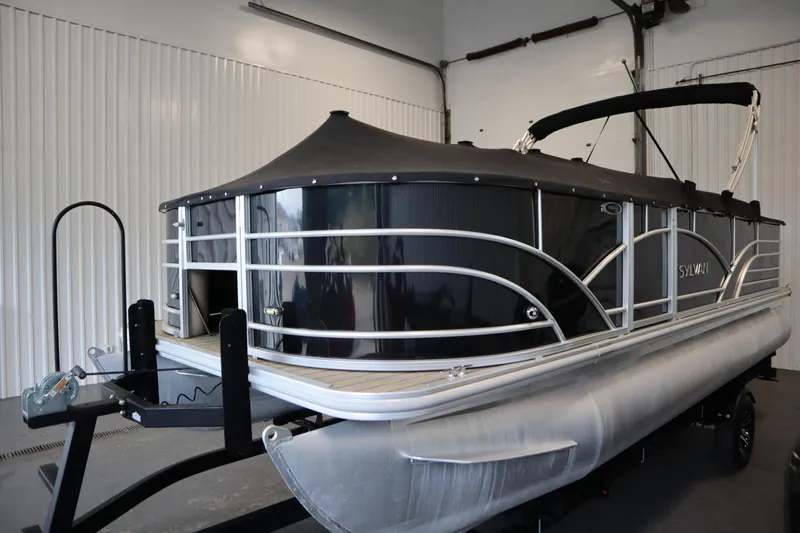 Slide: The Image of 2019 Sylvan 820 Mirage pontoon boat in a garage, covered and on a trailer. - 49