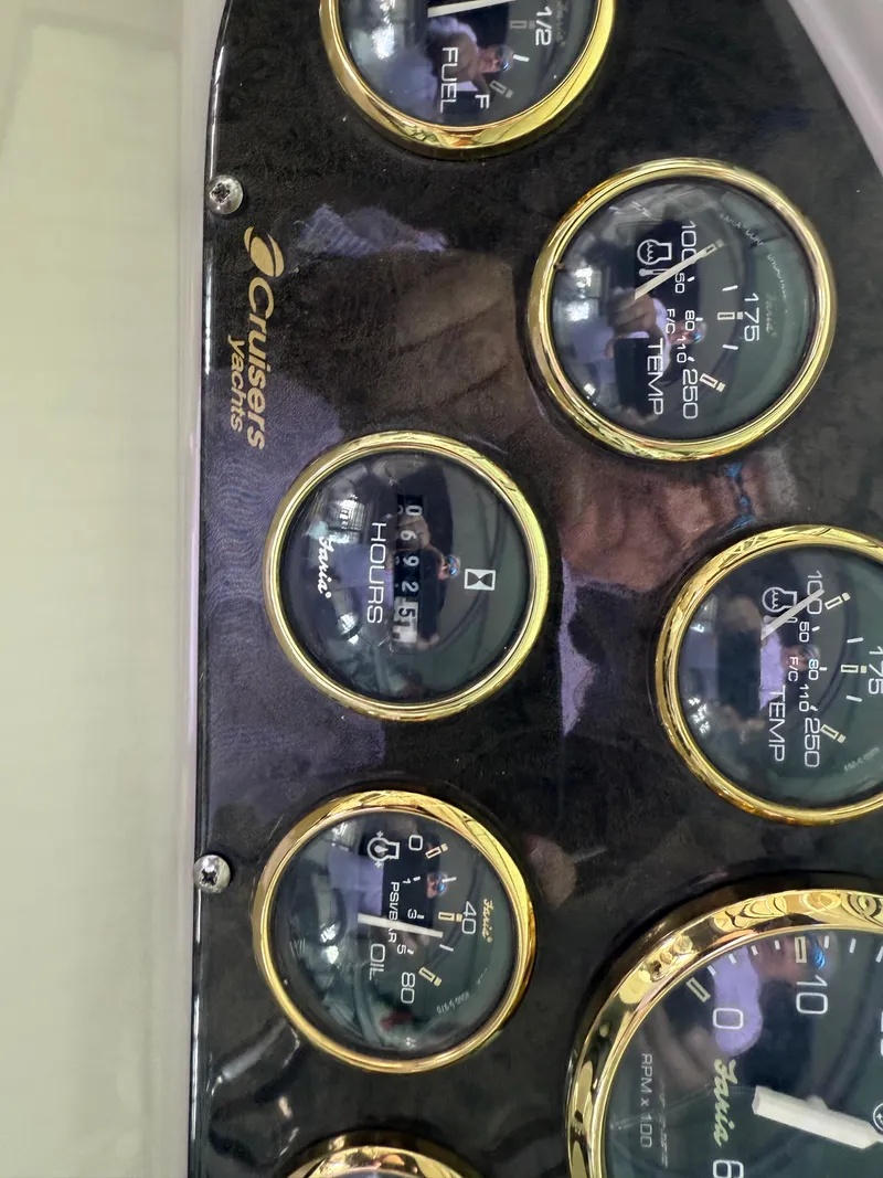 Slide: The Image of Dashboard gauges of a 2004 Cruisers Yachts 280 Express, showing fuel, temperature, and hours. - 10