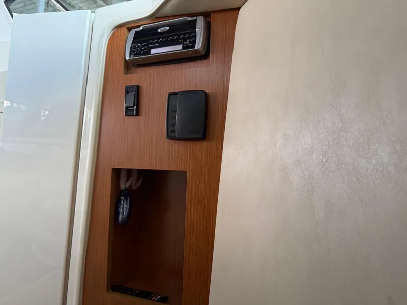 Slide: The Image of 2004 Cruisers Yachts 280 Express interior panel with stereo system and storage compartment. - 15