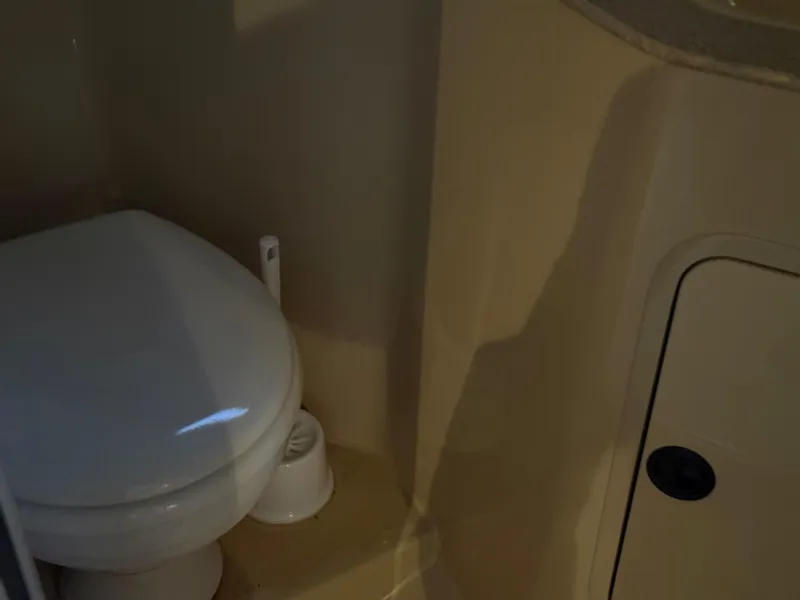 Slide: The Image of 2004 Cruisers Yachts 280 Express bathroom with toilet and storage compartment. - 17