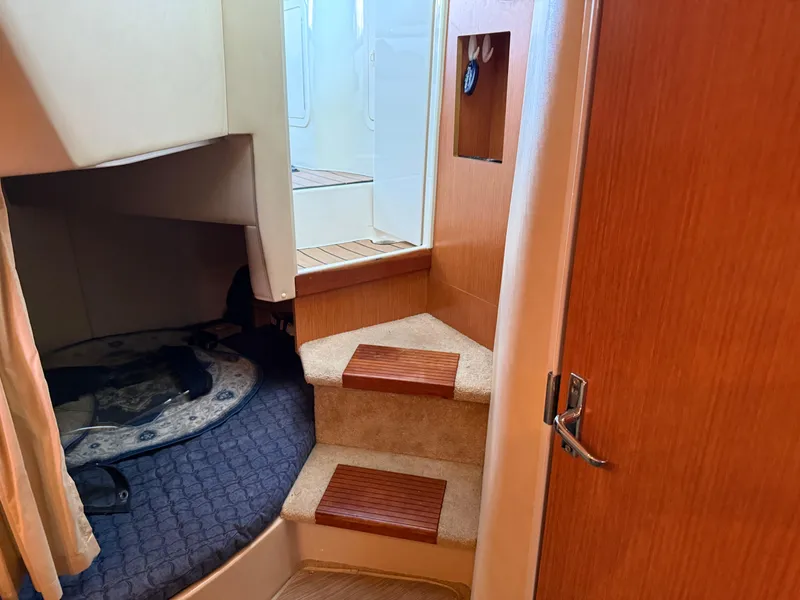 Slide: The Image of Interior of 2004 Cruisers Yachts 280 Express with steps and cozy sleeping area. - 19