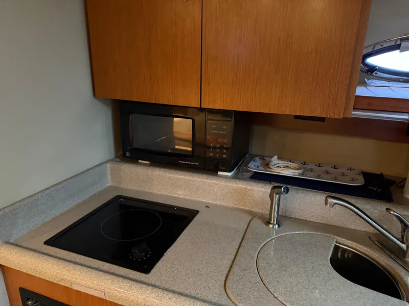 Slide: The Image of 2004 Cruisers Yachts 280 Express kitchen with stove, microwave, and sink. - 24