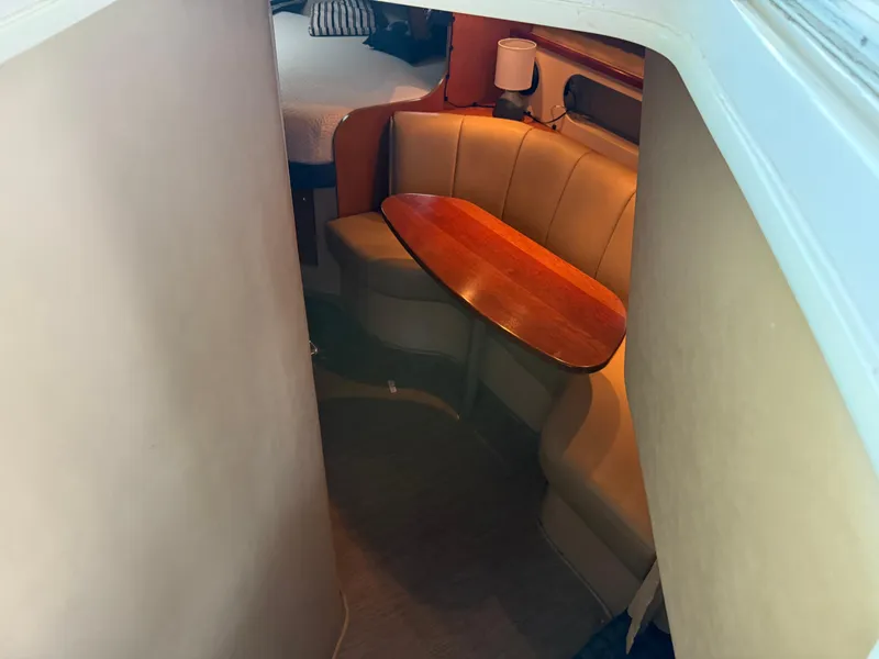 Slide: The Image of 2004 Cruisers Yachts 280 Express interior with cozy seating and wooden table. - 26