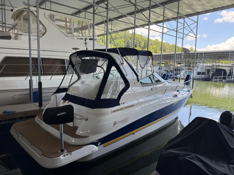 Slide: The Image of 2004 Cruisers Yachts 280 Express docked in a marina under a covered structure. - 6