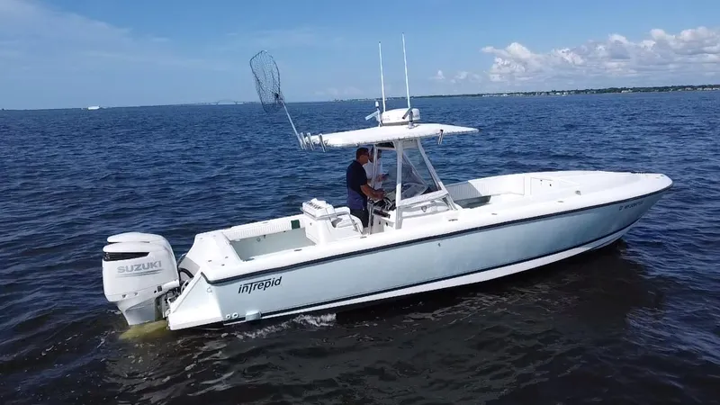 Slide: The Image of 1998 Intrepid 327 Cuddy boat cruising on open water with Suzuki outboard engine. - 10