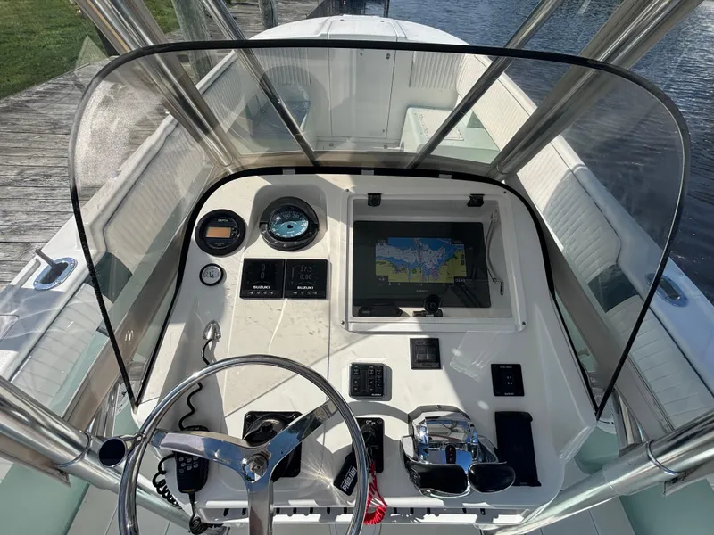 Slide: The Image of 1998 Intrepid 327 Cuddy boat dashboard with navigation system and steering wheel. - 12