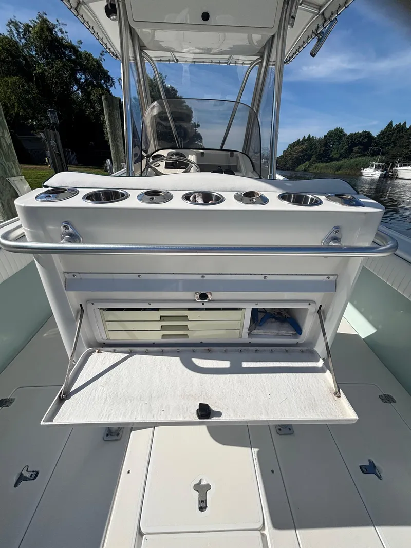 Slide: The Image of 1998 Intrepid 327 Cuddy boat interior with fishing rod holders and storage compartment. - 18