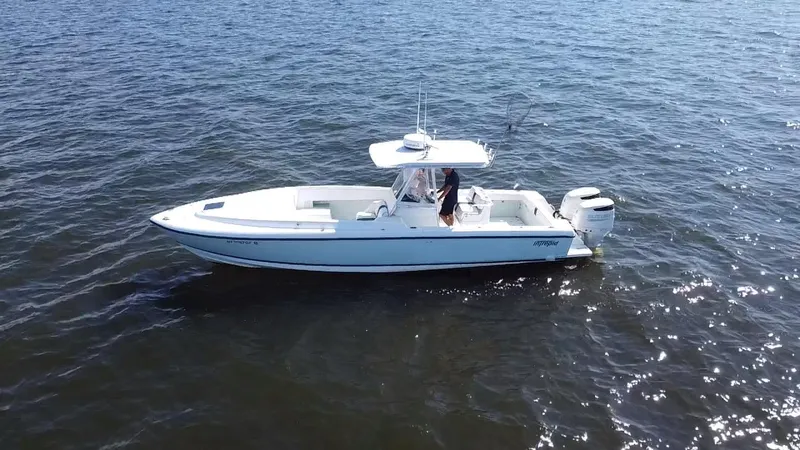 Slide: The Image of 1998 Intrepid 327 Cuddy boat on open water, side view. - 2