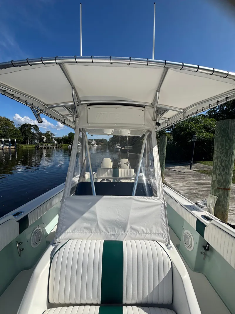 Slide: The Image of 1998 Intrepid 327 Cuddy boat docked, featuring a spacious seating area and canopy. - 20