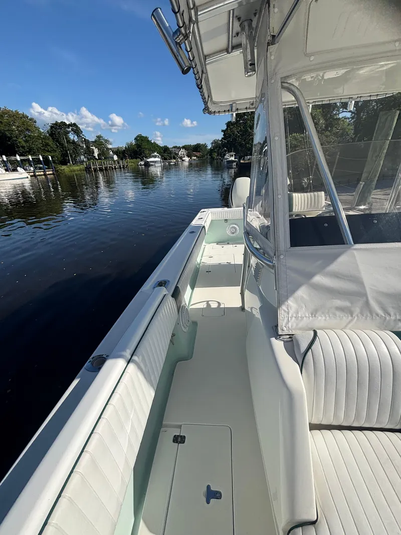 Slide: The Image of 1998 Intrepid 327 Cuddy boat on a calm river, showcasing sleek design and comfortable seating. - 21