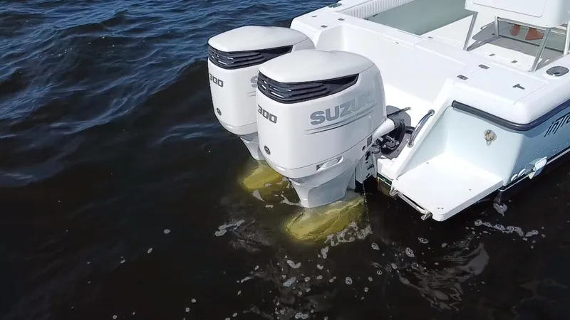 Slide: The Image of Twin Suzuki outboard engines on a 1998 Intrepid 327 Cuddy boat in water. - 33