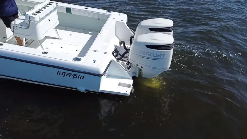 Slide: The Image of 1998 Intrepid 327 Cuddy boat with dual Suzuki outboard motors on water. - 34