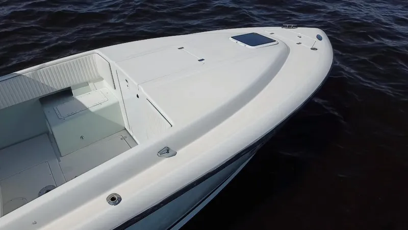 Slide: The Image of 1998 Intrepid 327 Cuddy boat on water, showcasing sleek design and spacious deck. - 37