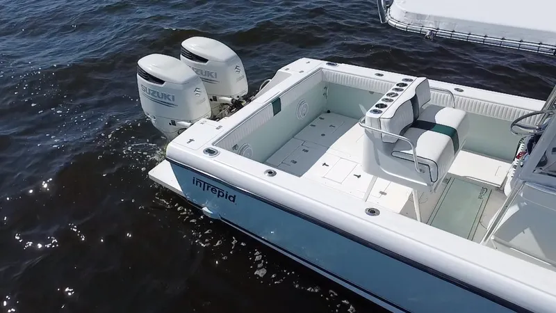Slide: The Image of 1998 Intrepid 327 Cuddy boat with dual Suzuki engines on water. - 39