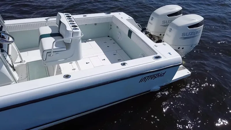 Slide: The Image of 1998 Intrepid 327 Cuddy boat with dual Suzuki engines on open water. - 40