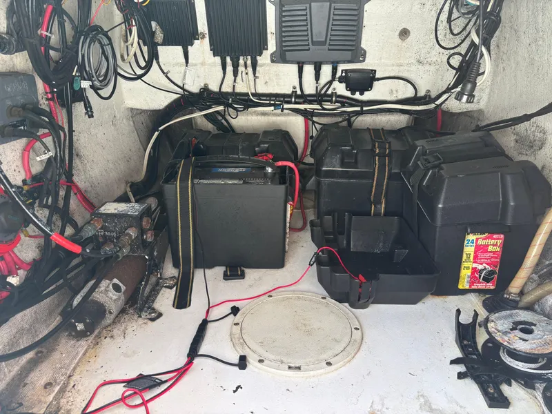 Slide: The Image of 1998 Intrepid 327 Cuddy boat battery compartment with wiring and equipment. - 43